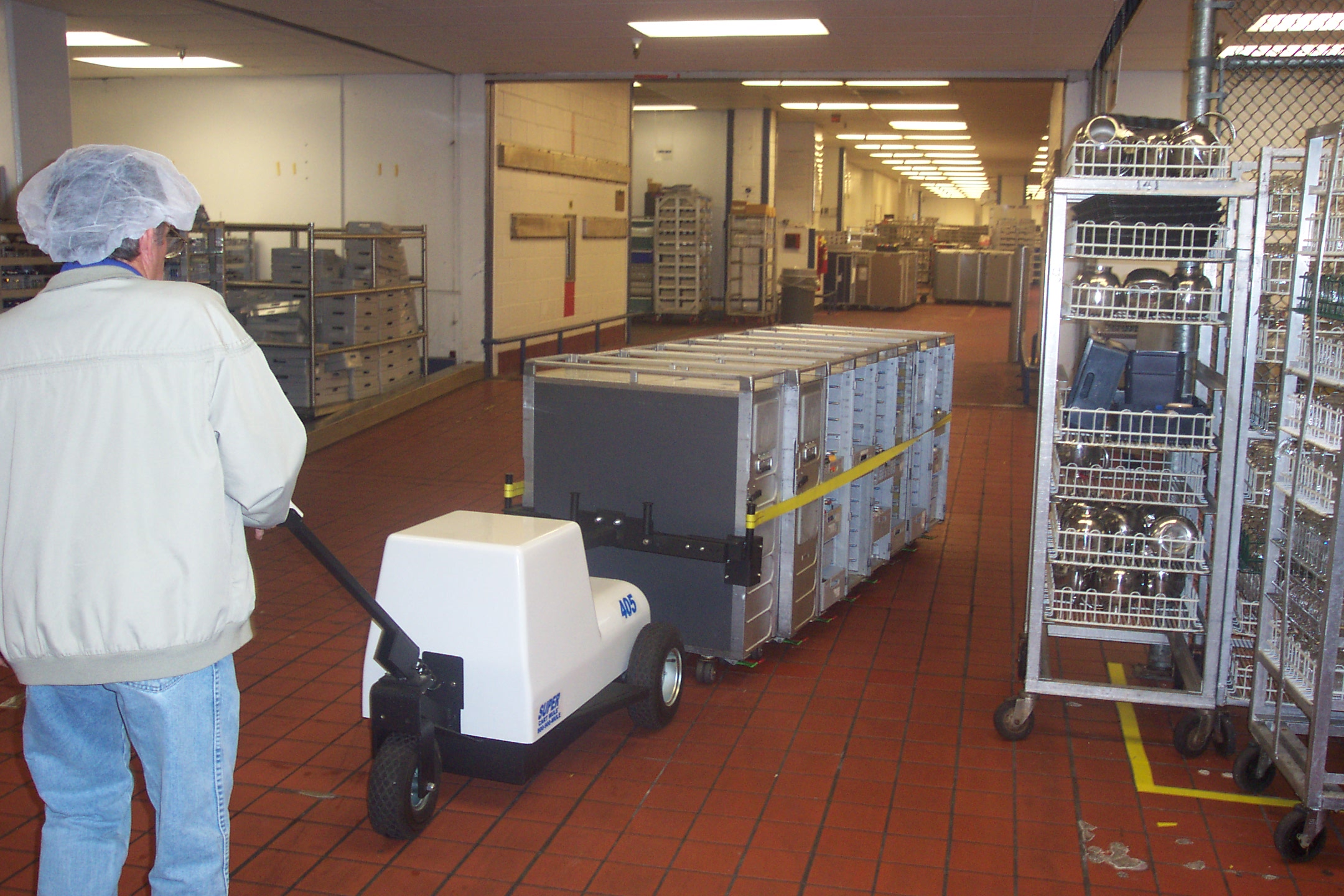 Cart Mule food cart mover moves a line of airline carts. 